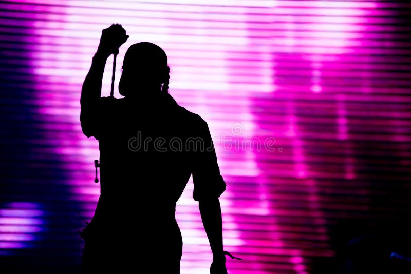 Silhouette of an artist singing live on the stage