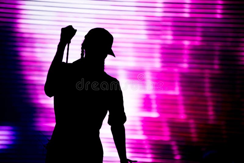 Silhouette of an artist singing live on the stage