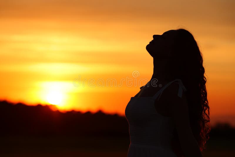 Side view portrait of a woman silhouette breathing fresh air at sunset or sunrise. Side view portrait of a woman silhouette breathing fresh air at sunset or sunrise