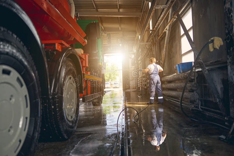 Silhouette of attentive woman washing big car stock image