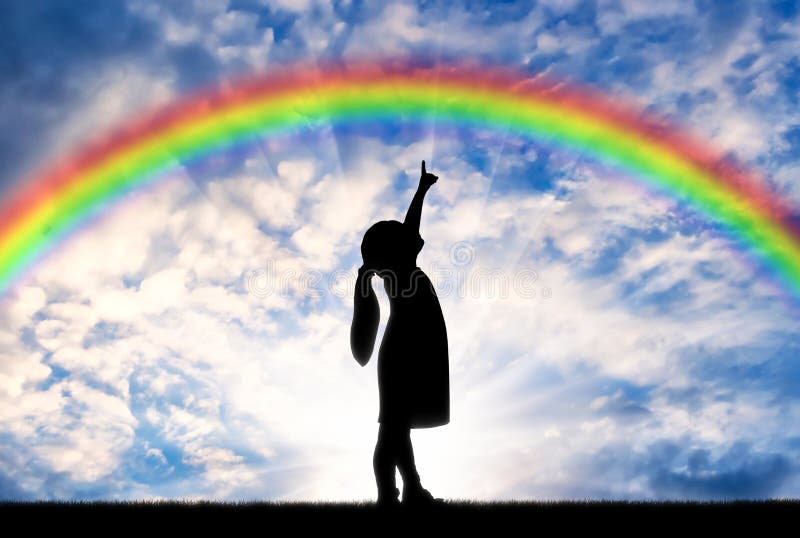 Silhouette of a baby girl showing a finger in the sky on a rainbow. Childhood
