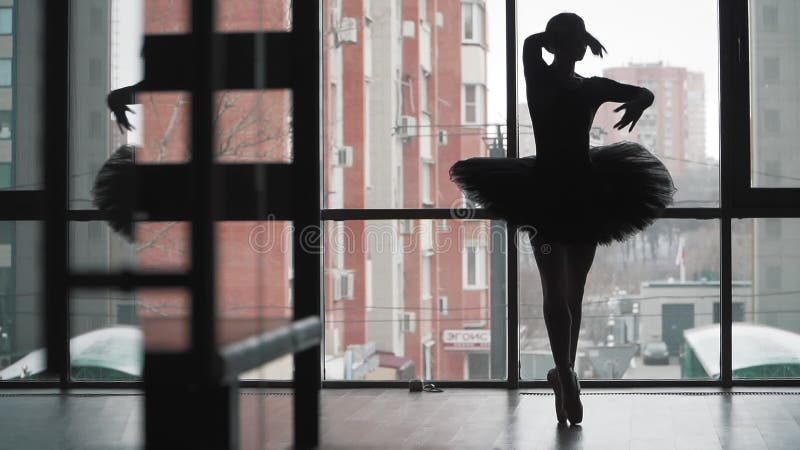 Silhouette Ballerina in un tutu nero che danza sullo sfondo della città Un bellissimo balletto in scarpe Pointe