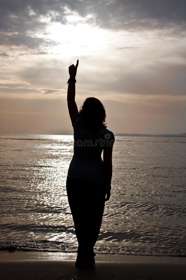 A silhouette of a beautiful girl against the sunset