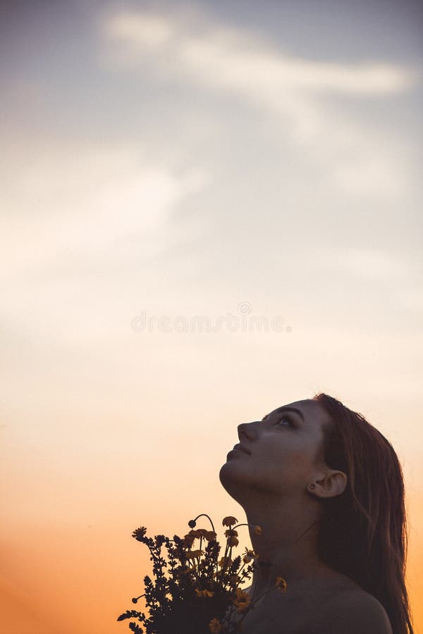 silhouette of a beautiful girl at sunset in a field, face profile of young  woman on nature Stock Photo