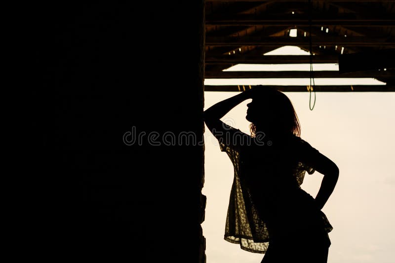 Silhouette of beautiful girl outdoor in old warehouse