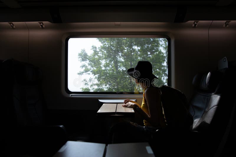 A silhouette of beautiful hipster asian woman traveling on the train.