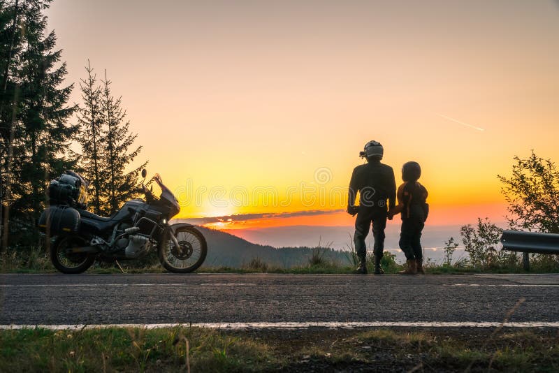 Silhouette of biker couple girl man and adventure motorcycle on the road with sunset light. Top of mountains, tourism motorbike, royalty free stock image Silhouette of biker couple girl man and adventure motorcycle on the road with sunset light. Top of mountains, tourism motorbike, royalty free stock image