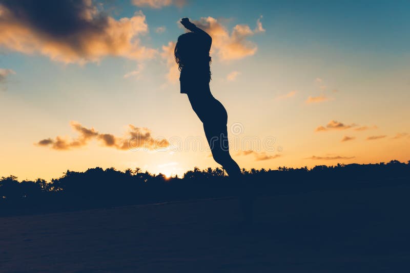 Silhouette of brunette jumping on beach at sunset, carefree and stress free woman on island. royalty free stock photography Silhouette of brunette jumping on beach at sunset, carefree and stress free woman on island. royalty free stock photography