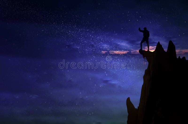 Silhouette of a champion man and the Universe.A person is standing on the top of the hill next to the Milky Way galaxy with