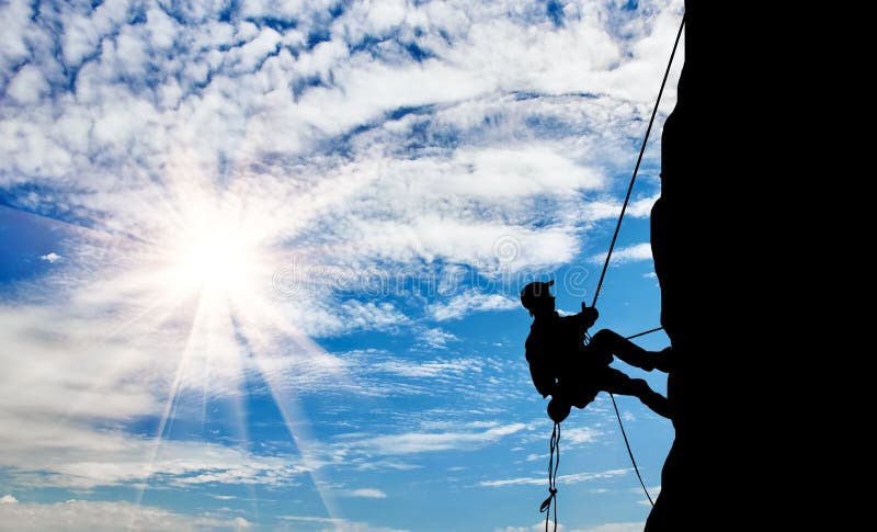 Silhouette climber climbing a mountain