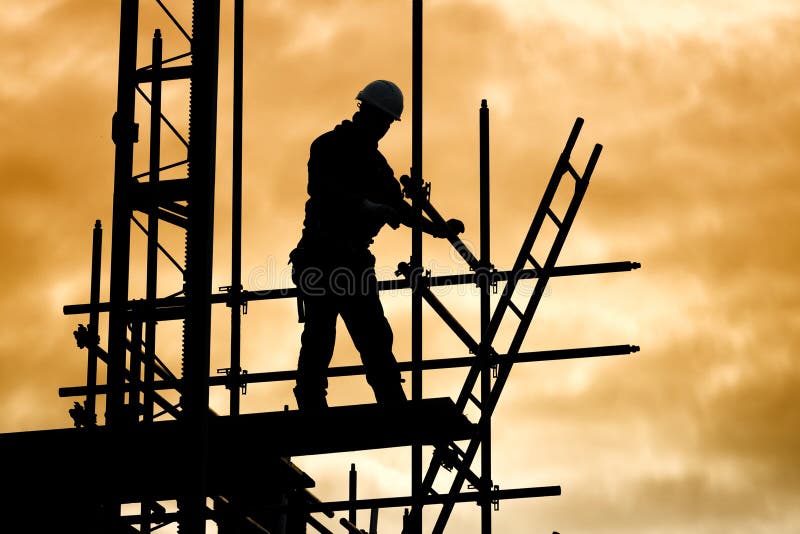 Silhouette di costruzione del lavoratore contro il cielo su di ponteggio con scala sulla costruzione sito al tramonto.