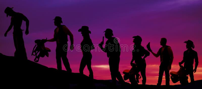 Silhouette of cowboys and cowgirls walking in a line in the suns