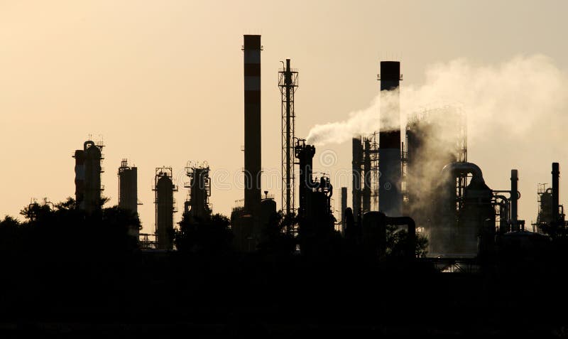 Sagoma nera di greggio in raffineria di petrolio stazione durante il tramonto.