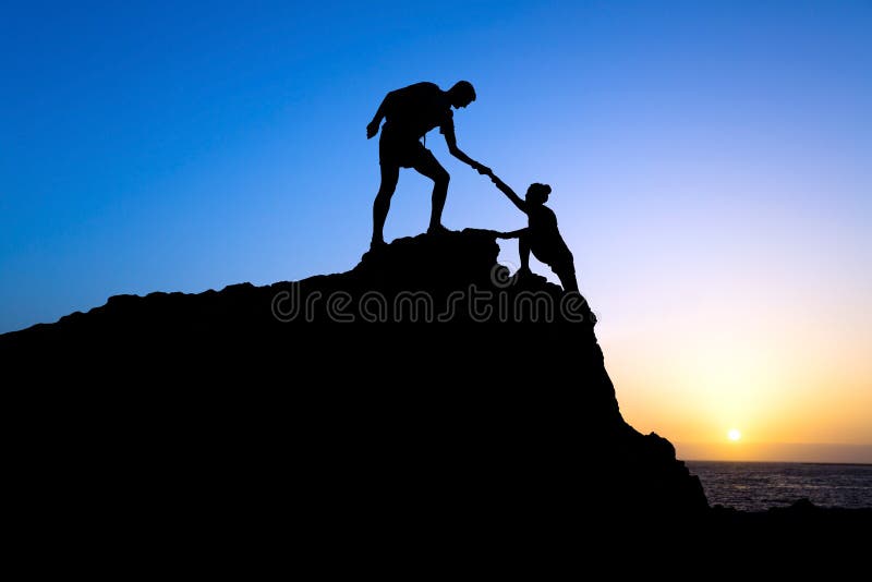 Silhouette d'aide d'homme et de femme en montagnes images libres de droits