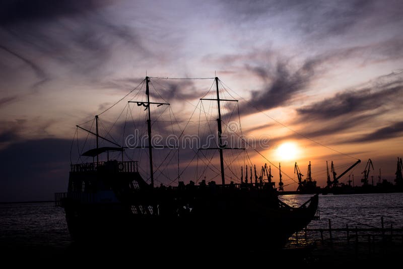 Silhouette d'un grand, vieux bateau au dock au coucher du soleil beau ciel lumineux photo stock Silhouette d'un grand, vieux bateau au dock au coucher du soleil beau ciel lumineux photo stock