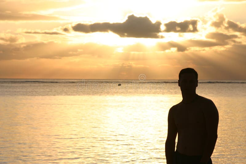 Silhouette of a man watching the sunset over the ocean. Silhouette of a man watching the sunset over the ocean