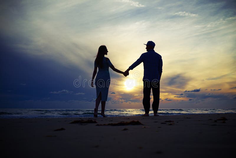 Silhouette de beaux couples fascinants tenant des mains aux uns photos libres de droits Silhouette de beaux couples fascinants tenant des mains aux uns photos libres de droits