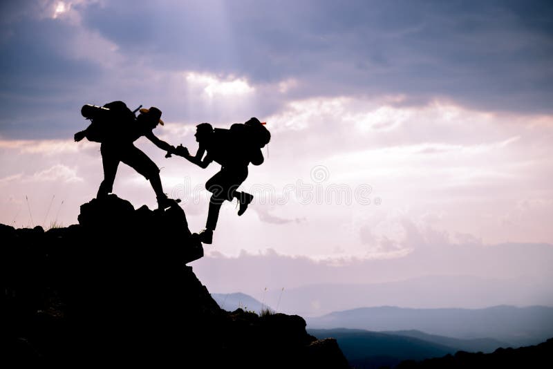 Silhouette de coup de main entre le grimpeur deux Personnes aventureuses ; Randonneurs s'élevant sur la montagne Aide, risque, ap photo libre de droits