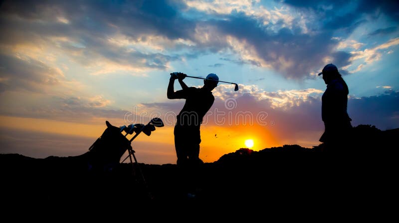 Silhouette de couples de golfeur au coucher du soleil photos stock Silhouette de couples de golfeur au coucher du soleil photos stock