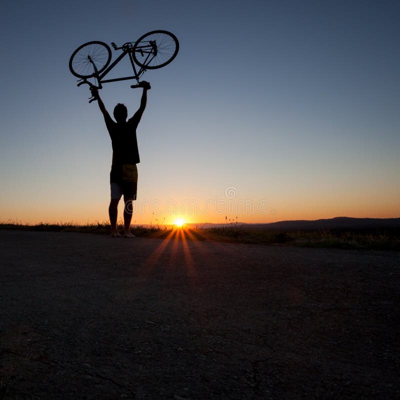 Silhouette de cycliste dans le coucher du soleil photo stock Silhouette de cycliste dans le coucher du soleil photo stock