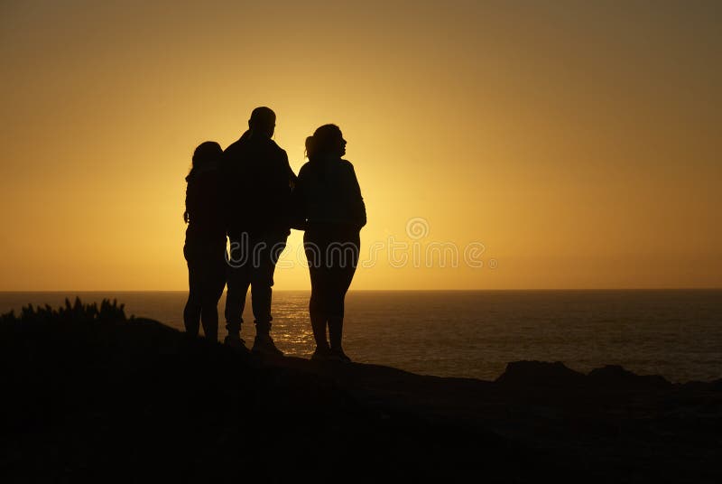 Silhouette de famille donnant sur l'océan images stock Silhouette de famille donnant sur l'océan images stock