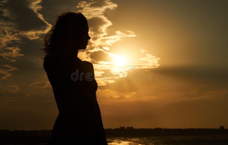 Silhouette de femme libre au coucher du soleil sur la plage photographie stock libre de droits Silhouette de femme libre au coucher du soleil sur la plage photographie stock libre de droits