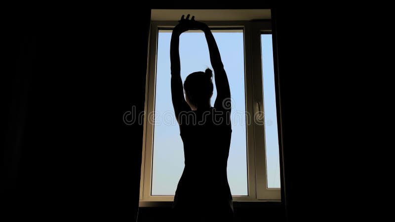 Silhouette de femme ouvrant les rideaux et regardant par la fenêtre arrière vue banque de vidéos