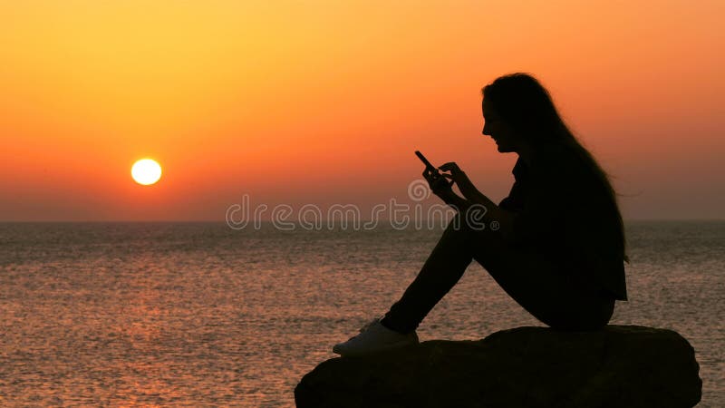 Silhouette de femme utilisant le téléphone intelligent sur la plage clips vidéos
