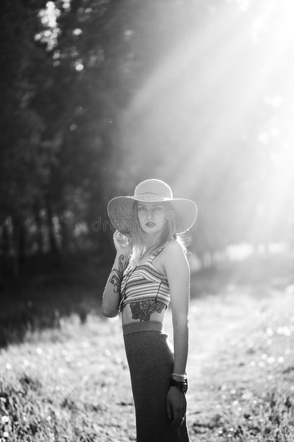 Silhouette de fille marchant en parc extérieur Concept ensoleillé de mode de vie d'été Femme dans la robe et le chapeau dans le d image stock Silhouette de fille marchant en parc extérieur Concept ensoleillé de mode de vie d'été Femme dans la robe et le chapeau dans le d image stock