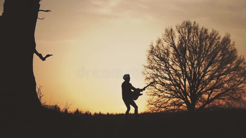 Silhouette de guitariste au mouvement lent de coucher du soleil