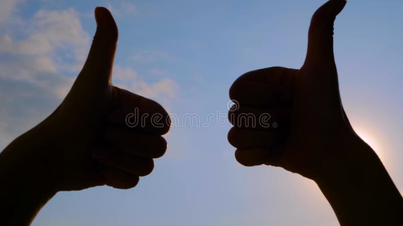 Silhouette de la femme montre deux mains avec pouces vers le haut geste éblouissement de la lentille de soleil banque de vidéos