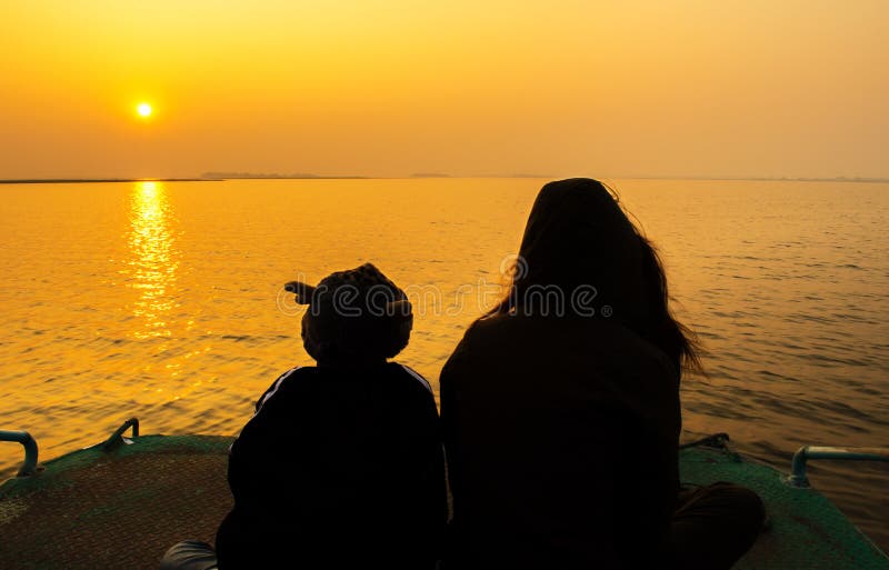 Silhouette de mère et d'enfants dans le coucher du soleil images libres de droits Silhouette de mère et d'enfants dans le coucher du soleil images libres de droits