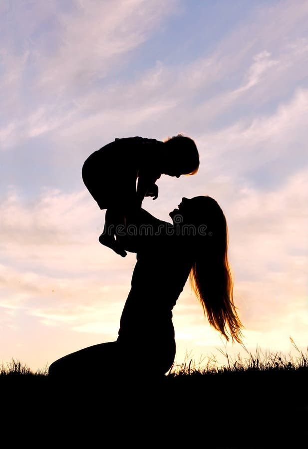 Silhouette de mère heureuse jouant dehors avec le bébé images libres de droits