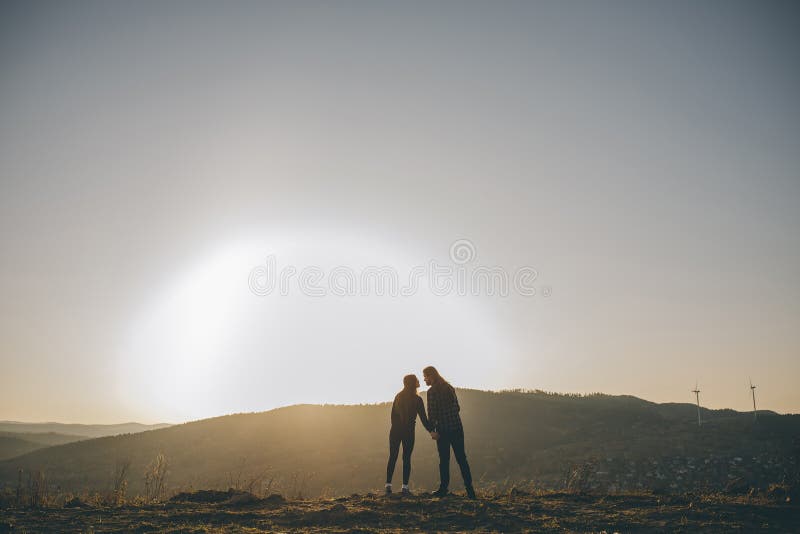 Silhouette del bacio della coppia romantica Coppia che tiene le mani Coppia di amanti che tiene la mano con l'alba fotografie stock