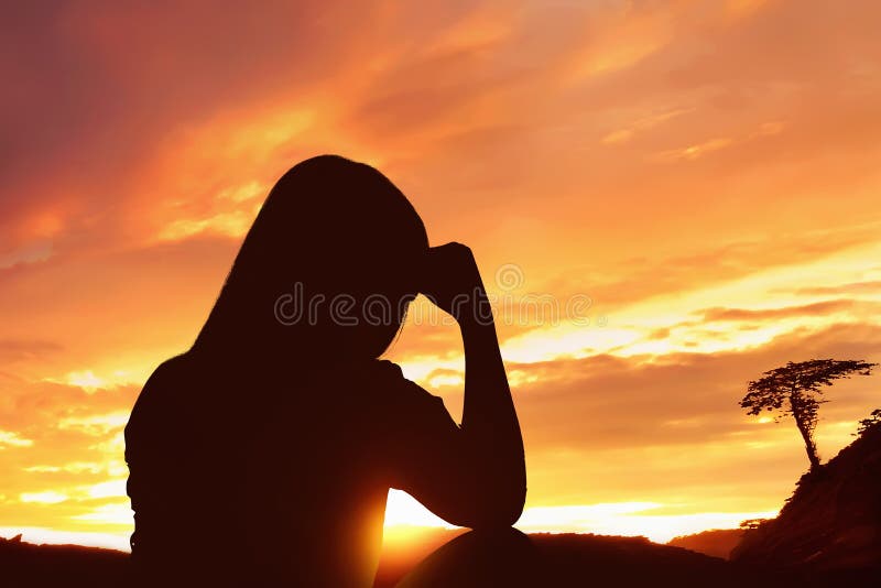 Silhouette depressed woman sitting alone on top of the mountain