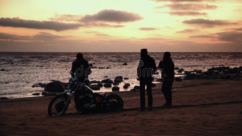 Silhouette des motards et de la moto avec le fond de lever de soleil