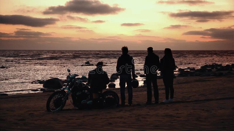 Silhouette des motards et de la moto avec le fond de lever de soleil