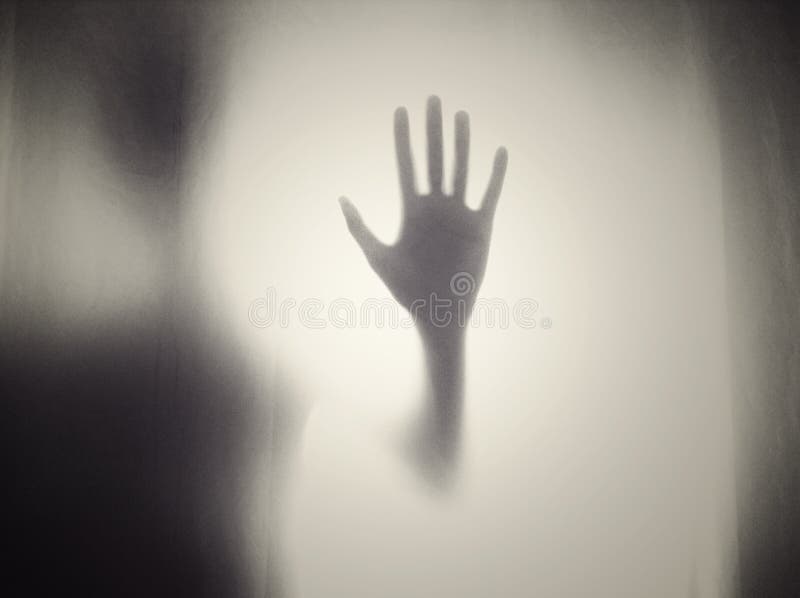Silhouette di una persona raccapricciante su una porta di vetro - concetto orrore