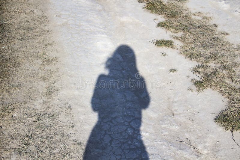 Silhouette di una ragazza su una strada gessata L'ombra sulla strada