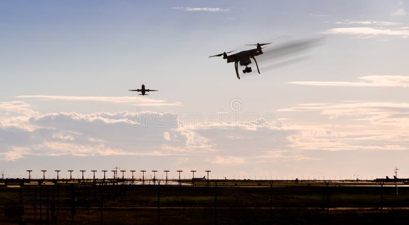 A silhouette of a drone rapidly moving towards an departing aircraft near a airport. royalty free stock photos A silhouette of a drone rapidly moving towards an departing aircraft near a airport. royalty free stock photos