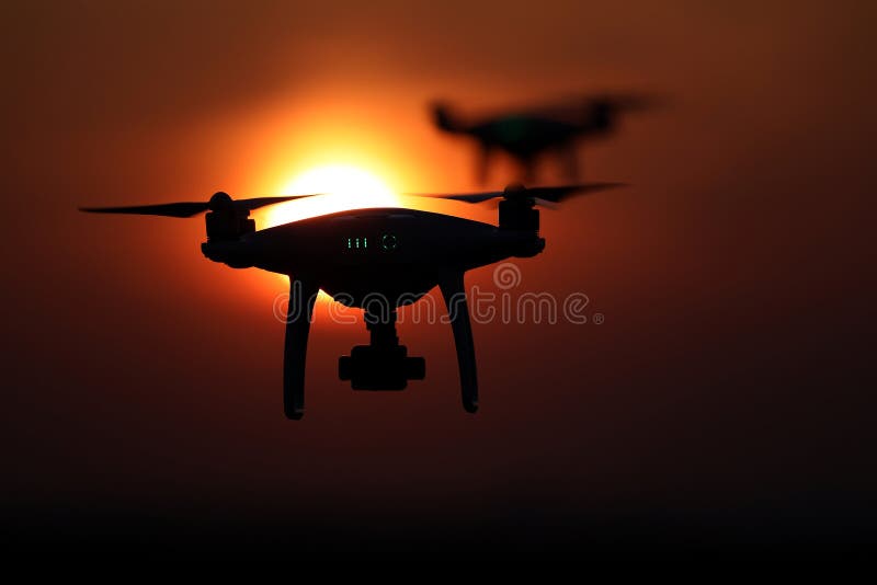 Silhouette of drones in the sky, red sunset