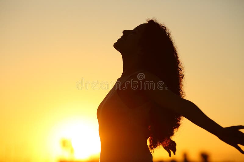 Side view silhouette of a lady breathing deeply fresh air at sunset. Side view silhouette of a lady breathing deeply fresh air at sunset