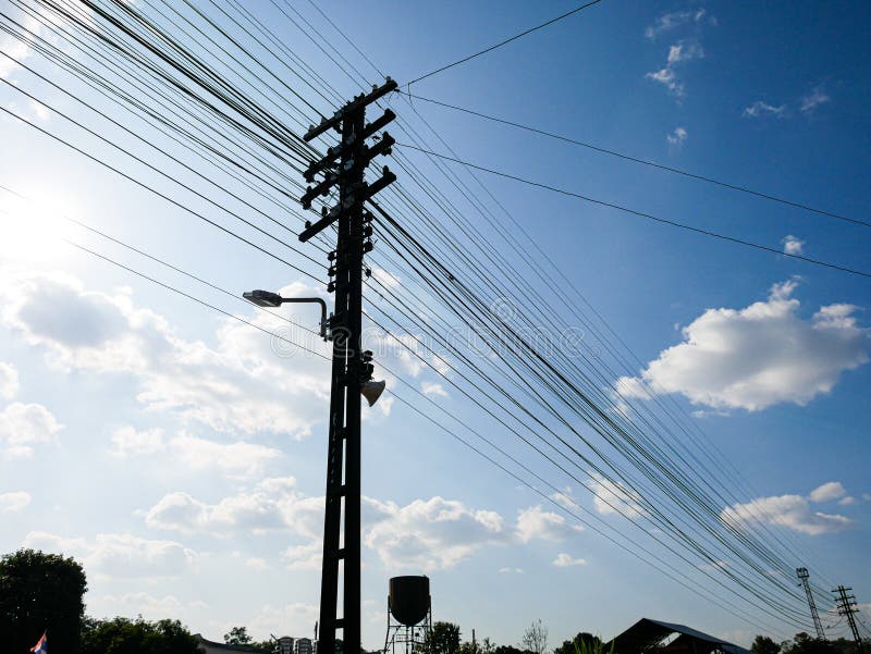 Silhouette Electric pole connect to the high voltage electric wires on sunlight blue sky. Structure line wire power electrical.