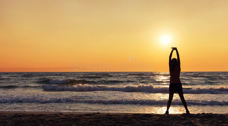 Silhouette of female athlete doing stretches on the beach royalty free stock photography Silhouette of female athlete doing stretches on the beach royalty free stock photography