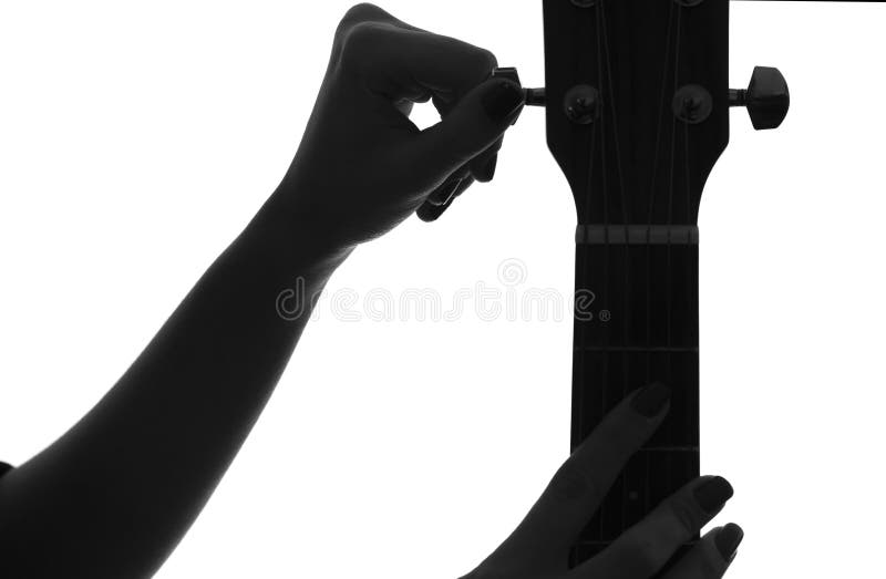 Silhouette of a female hand tune a guitar royalty free stock photo Silhouette of a female hand tune a guitar royalty free stock photo