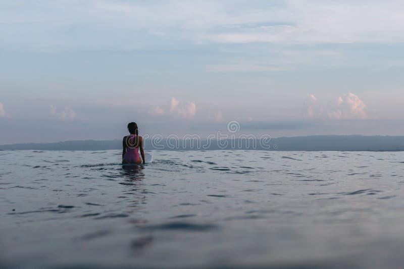 silhouette of female surfer sitting on surfboard royalty free stock photo silhouette of female surfer sitting on surfboard royalty free stock photo