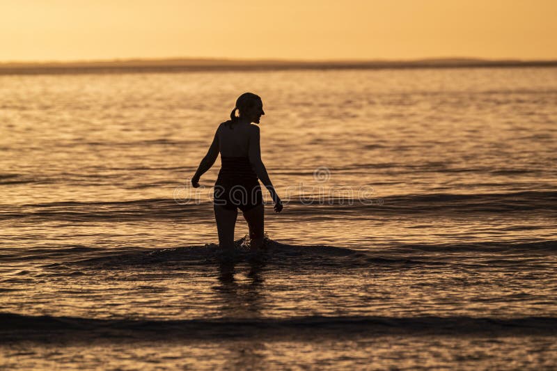 Silhouette of Female Swimmer Going into the Atlantic Ocean in Ireland Silhouette of Female Swimmer Going into the Atlantic Ocean in Ireland