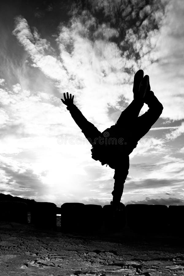 Silhouette of girl doing a one arm handstand