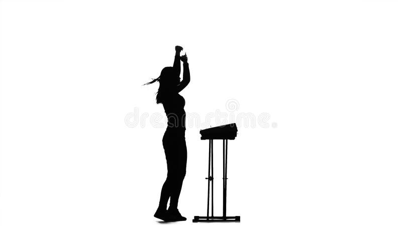 Silhouette of the girl in the half turn plays the piano