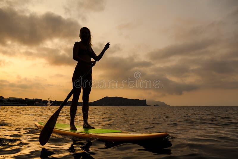 Silhouette of a girl on Stand Up Paddle Board